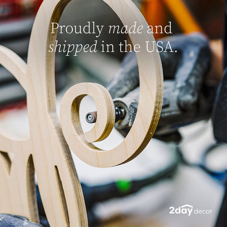 May include: A light-colored wooden cutout with a spiral design being sanded by a rotary tool. The text Proudly made and shipped in the USA is visible at the top, and the text 2day decor is visible in the bottom right corner of the image.
