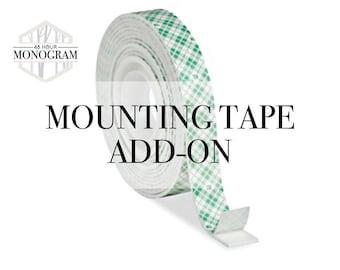 May include: A roll of double-sided mounting tape featuring a white foam core and a green checkered protective liner. The text 48 HOUR MONOGRAM is visible in a hexagonal logo, with the words MOUNTING TAPE ADD-ON printed in black across the center.