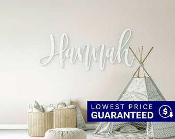 May include: A white wall-mounted sign featuring the name Hannah in a cursive script font. The sign is displayed above a gray and white star-patterned teepee tent and two woven wicker baskets, creating a decorative arrangement for a room.