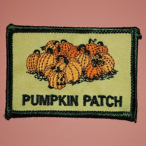 May include: A green embroidered patch with a pile of orange and yellow pumpkins and the text "Pumpkin Patch".