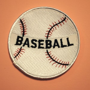 May include: White embroidered baseball patch with red stitching and the word "BASEBALL" in black lettering.