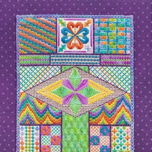 May include: A colourful cross-stitch embroidery design featuring a variety of geometric patterns and floral motifs. The design is stitched on white fabric and framed with a purple border.