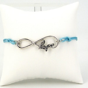 May include: A light blue bracelet with an infinity symbol charm that says "Hope" in cursive.