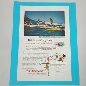 May include: A vintage Pan American airline advertisement featuring a colour photograph of people surfing in Hawaii. The text includes With trade winds in your hair and work 2500 miles behind, Pan American World Airways, and a mail-in coupon form.