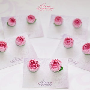 Pode incluir: Brincos de flores cor-de-rosa em cart&otilde;es brancos com o texto "Anna Lamunova" em cada cart&atilde;o.
