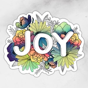May include: A sticker featuring the word "JOY" in white block letters, surrounded by a colorful floral arrangement. The flowers include shades of blue, purple, yellow, orange, and green, with black outline details. The background is a marble-like pattern.