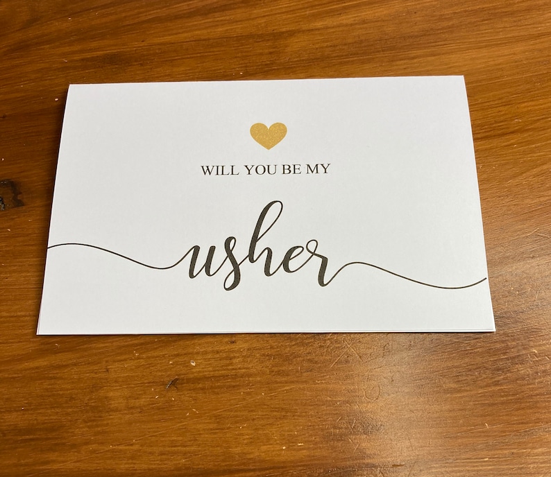 Puede incluir: Tarjeta blanca con un coraz&oacute;n dorado y el texto "&iquest;Quieres ser mi padrino?" en escritura cursiva negra.