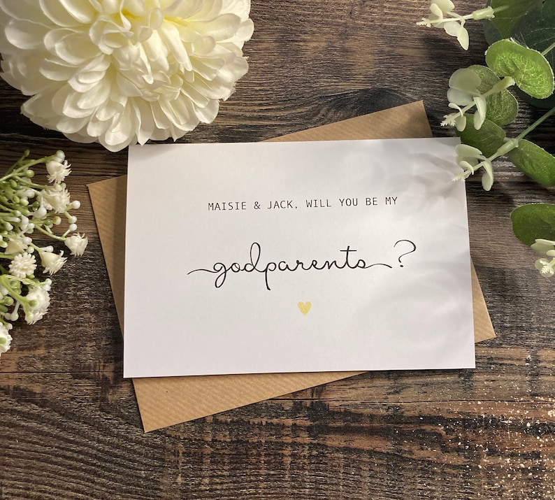 Pu&ograve; includere: Carta bianca con testo nero che dice "Maisie & Jack, volete essere i miei padrini?" con un piccolo cuore dorato.