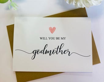 Può includere: Un biglietto bianco con un cuore rosa e il testo "Vuoi essere la mia madrina?" in corsivo nero.