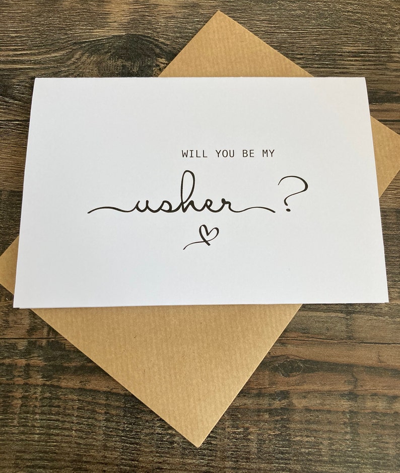 May include: White card with black text that reads "Will you be my usher?" with a small heart drawn underneath the text.