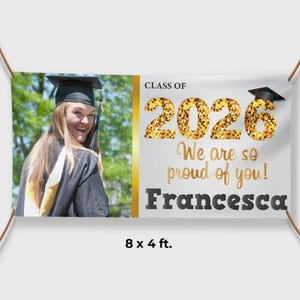 May include: A graduation banner featuring a graduate in a cap and gown. The banner displays "CLASS OF 2026 We are so proud of you! Francesca." The banner is 244 x 122 cm.