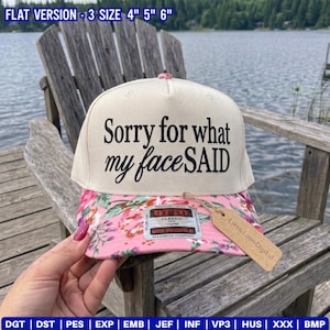 May include: A cream-colored baseball cap with the black text Sorry for what my faceSAID printed on the front. The brim features a pink floral pattern. A brown cardboard tag is attached to the brim, which lists available sizes of 4, 5, and 6 inches.