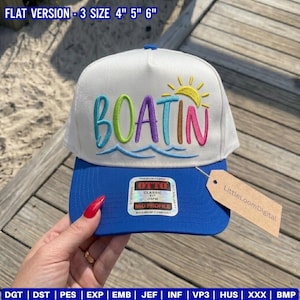 May include: A white and blue baseball cap featuring the embroidered text BOATIN in multi-coloured letters above a blue wave graphic and a yellow sun. The cap includes a silver Otto brand sticker on the brim and a brown cardboard tag attached to the side.