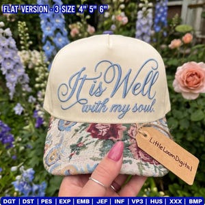 May include: Cream-colored baseball cap with the embroidered phrase "It is Well with my soul" in light blue script. The brim features a floral tapestry design. A small tag reads "Little Loom Digital".