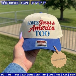 May include: A baseball cap with a cream-colored crown and a blue brim. The cap features the embroidered text "LOVES Jesus & America TOO" in red and blue. A tag with the text "LittleLoomDigital" is attached.