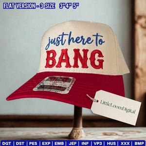May include: A baseball cap with a red brim and a cream-colored crown. The text "just here to BANG" is embroidered in blue and red. A tag with "LittleLoomDigital" is attached. The hat is displayed on a wooden stand.