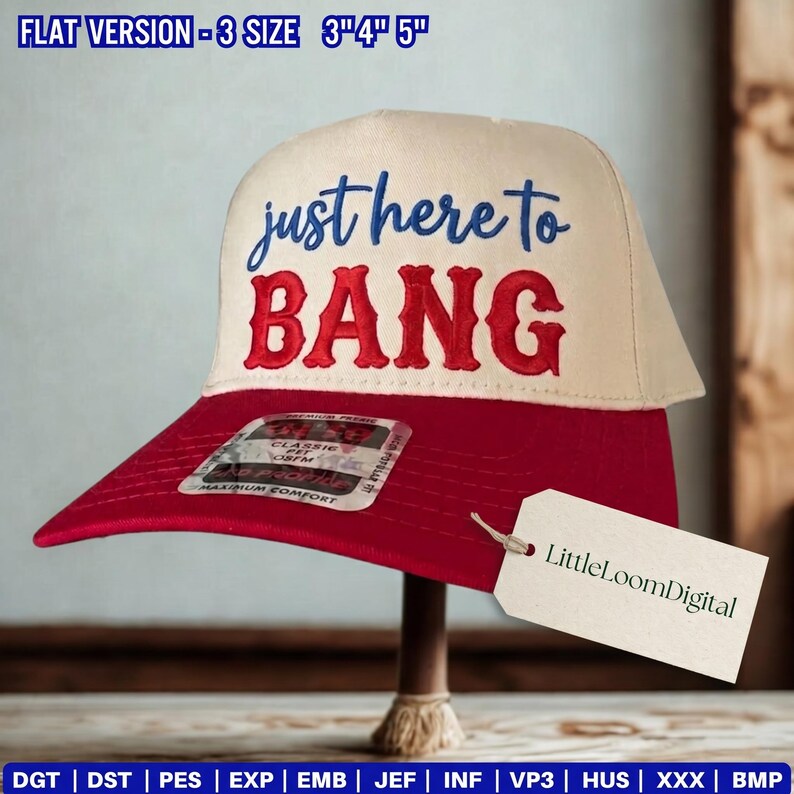 May include: A baseball cap with a red brim and a cream-colored crown. The text "just here to BANG" is embroidered in blue and red. A tag with "LittleLoomDigital" is attached. The hat is displayed on a wooden stand.