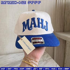 May include: A white and blue baseball cap with the word "MAHJ" embroidered in blue. The cap has a flat brim and a tag that says "LittleLoomDigital". The cap is available in sizes 3", 4", 5", and 6".
