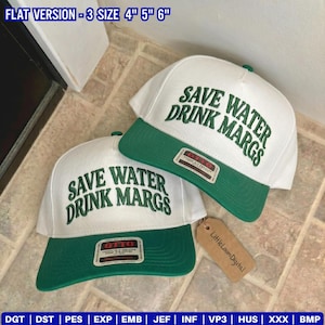 May include: Two white and green baseball caps with the text "SAVE WATER DRINK MARGS" in green. The caps have a green brim and a small tag that says "Little Loom Digital".