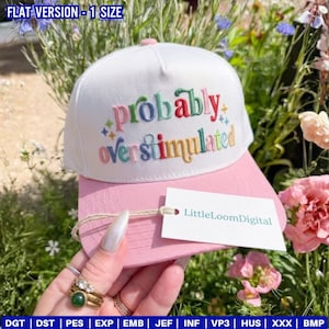 May include: A white and pink baseball cap with the embroidered text "probably overstimulated" in colorful letters. The cap has a pink brim and a white crown. A tag with the text "LittleLoomDigital" is attached.