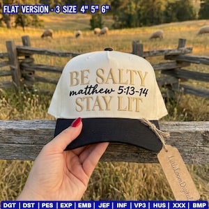 Könnte beinhalten: Eine cremefarbene Baseballkappe mit schwarzem Schirm und dem gestickten Text BE SALTY matthew 5:13-14 STAY LIT in Gold und Schwarz. Die Kappe hat ein braunes Papieretikett und ist in flachen Versionen von 10, 13 und 15 cm erhältlich.