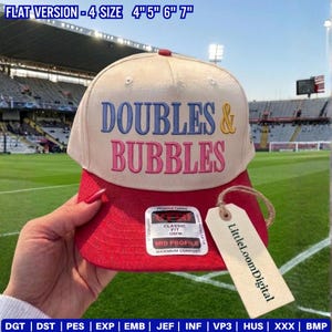 May include: A beige and red baseball cap with the words "DOUBLES & BUBBLES" embroidered on the front. The cap has a red brim and a tag that says "LittleLoomDigital". The hat is a classic fit and OSFM.