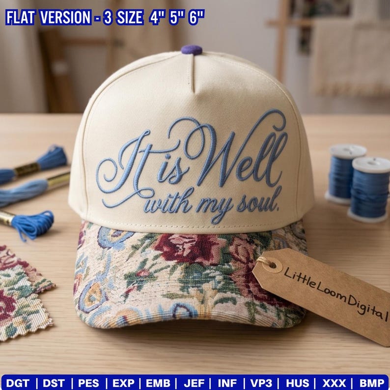 May include: Cream-colored baseball cap with the embroidered phrase "It is Well with my soul" in light blue script. The brim features a floral pattern. A small purple button is on top. The tag reads "Little Loom Digital".