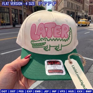Puede incluir: Gorra de béisbol beige y verde con la palabra "LATER" en rosa y un diseño de cocodrilo verde. La gorra tiene una visera plana y una etiqueta que dice "LittleLoomDigital". Las tallas de sombrero son 12.7cm, 15.2cm, 17.8cm y 20.3cm.