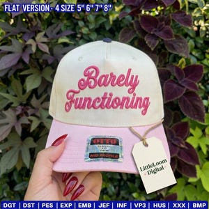 May include: A baseball cap with a cream crown and a pink peak. The words "Barely Functioning" are embroidered in pink script. The hat has a tag that says "LittleLoom + Digital".
