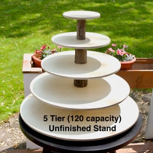 May include: A five-tier unfinished wooden cake stand with a natural wood center pole. The stand is 120 capacity and is shown on a black surface.
