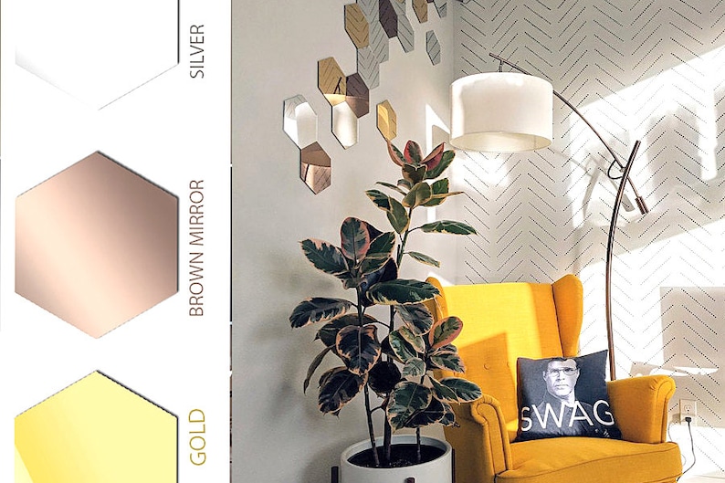 Puede incluir: Un sill&oacute;n amarillo con un coj&iacute;n negro que dice "SWAG". Una gran planta en maceta est&aacute; al lado del sill&oacute;n. La pared detr&aacute;s del sill&oacute;n tiene un patr&oacute;n geom&eacute;trico de espejos hexagonales plateados.