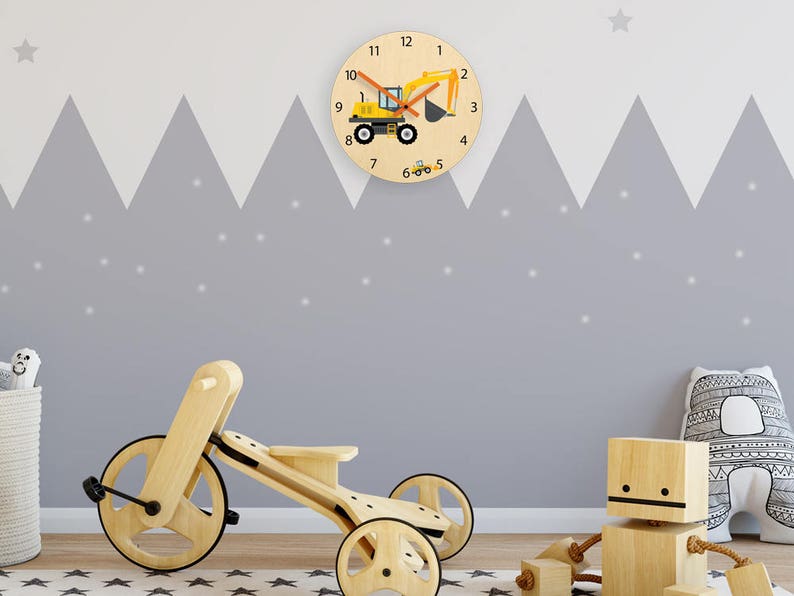 May include: A yellow toy excavator with a wooden clock face featuring black numbers and a gray background. The clock is mounted on a gray wall with a white star above it. A wooden toy tricycle and a wooden toy robot are in the foreground.