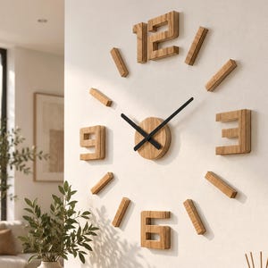 Puede incluir: Un reloj de pared con números y marcadores de madera individuales dispuestos en un patrón circular. El reloj tiene un centro circular de madera con dos manecillas negras delgadas. Los números 12, 3, 6 y 9 tienen un acabado de madera en capas.