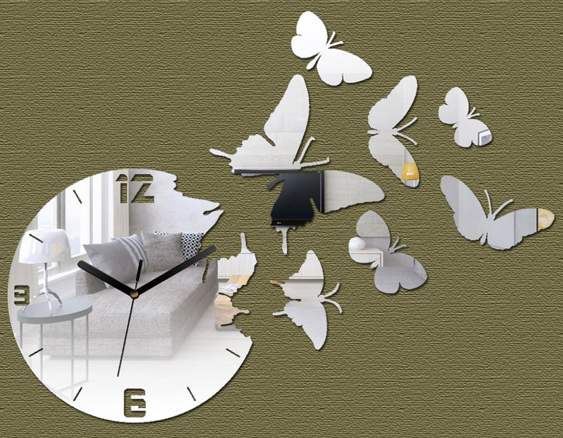 May include: A white mirrored clock with black hands and Roman numerals. The clock is surrounded by a design of white mirrored butterflies.