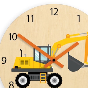 May include: A yellow and black toy excavator with an orange hand on a wooden clock face with black numbers 1 through 12.