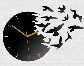 May include: A black clock with gold hands and a design of birds flying out of the clock face.