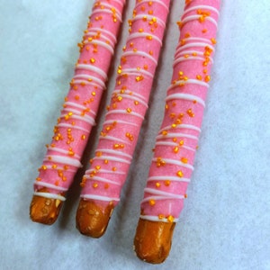 12 Pink Chocolate Covered Pretzels with White Chocolate Drizzle and Gold Sprinkles