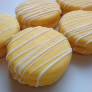12 Yellow Chocolate Covered Oreo Cookies with White Chocolate Drizzle