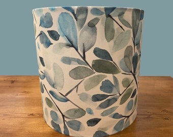 May include: A white lampshade with a blue and green watercolor leaf pattern.