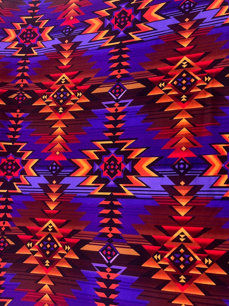 Puede incluir: Primer plano de una tela con un patr&oacute;n geom&eacute;trico en tonos morado, naranja y marr&oacute;n. El dise&ntilde;o presenta formas repetidas de diamantes y flechas, creando una est&eacute;tica de inspiraci&oacute;n suroeste o nativa americana. La tela tiene una apariencia texturizada.
