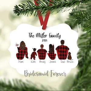 Pu&ograve; includere: Ornamento natalizio in metallo bianco con un nastro rosso. Presenta un'illustrazione di famiglia in pigiami a quadri rossi e neri abbinati, con il testo "The Miller Family 2023" e "Bridesmaid Forever".