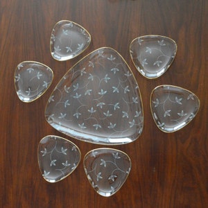 Puede incluir: Juego de seis platos de servir de vidrio transparente con borde dorado y un delicado patrón de hojas. Los platos son de forma triangular y vienen en varios tamaños.