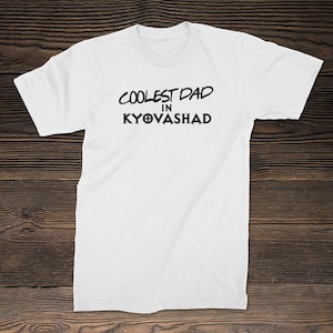 Puede incluir: Camiseta blanca con texto negro que dice "Coolest Dad in Kyovasha".