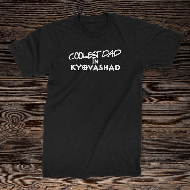 Puede incluir: Camiseta negra con texto blanco que dice "Coolest Dad in Kyovasha".