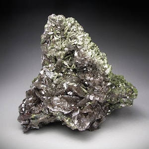 May include: A cluster of gray and silver crystals with green accents. The crystals are arranged in a jagged, irregular shape, resembling a small mountain.