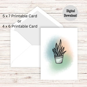 Może przedstawiać: Drukowana karta z ręcznie rysowaną ilustracją sansewierii w doniczce na tle akwarelowym w odcieniach niebieskiego, zielonego i pomarańczowego.