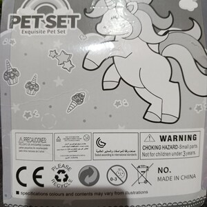 May include: A gray and white package with a black and white illustration of a unicorn. The package has the text "PET SET Exquisite Pet Set" and "3+AGES". The package also has a warning label that says "WARNING CHOKING HAZARD - Small parts. Not for children under 3 years."