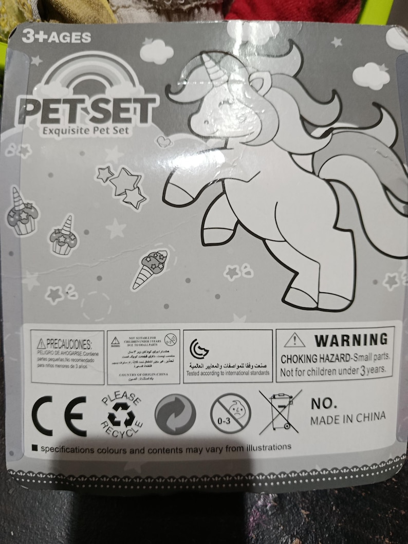 May include: A gray and white package with a black and white illustration of a unicorn. The package has the text "PET SET Exquisite Pet Set" and "3+AGES". The package also has a warning label that says "WARNING CHOKING HAZARD - Small parts. Not for children under 3 years."