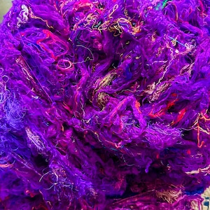 May include: A close-up of a pile of purple, pink, and blue silk fibers. The fibers are soft and fluffy, and they are perfect for crafting.