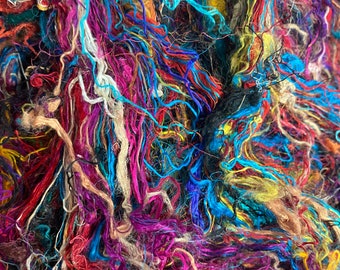 May include: Close-up of a vibrant, tangled mass of colorful yarn. The yarn features a mix of bright hues, including red, blue, purple, and yellow. The texture appears soft and slightly fuzzy, suggesting a fiber craft material.
